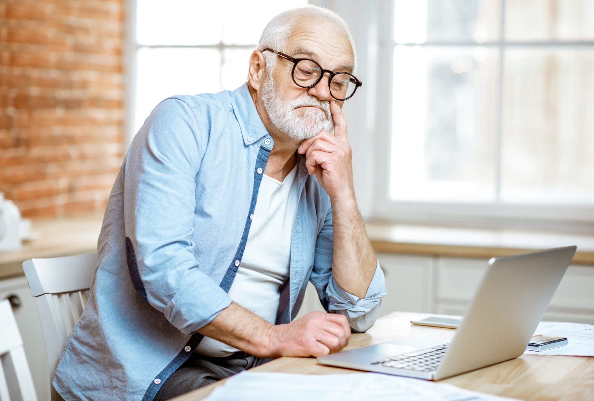 Senior man with laptop at home
